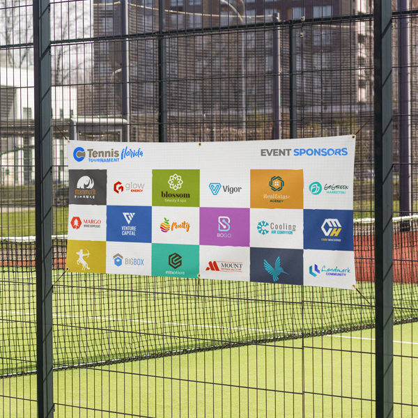 Tennis court with event sponsors' logos displayed on a banner.