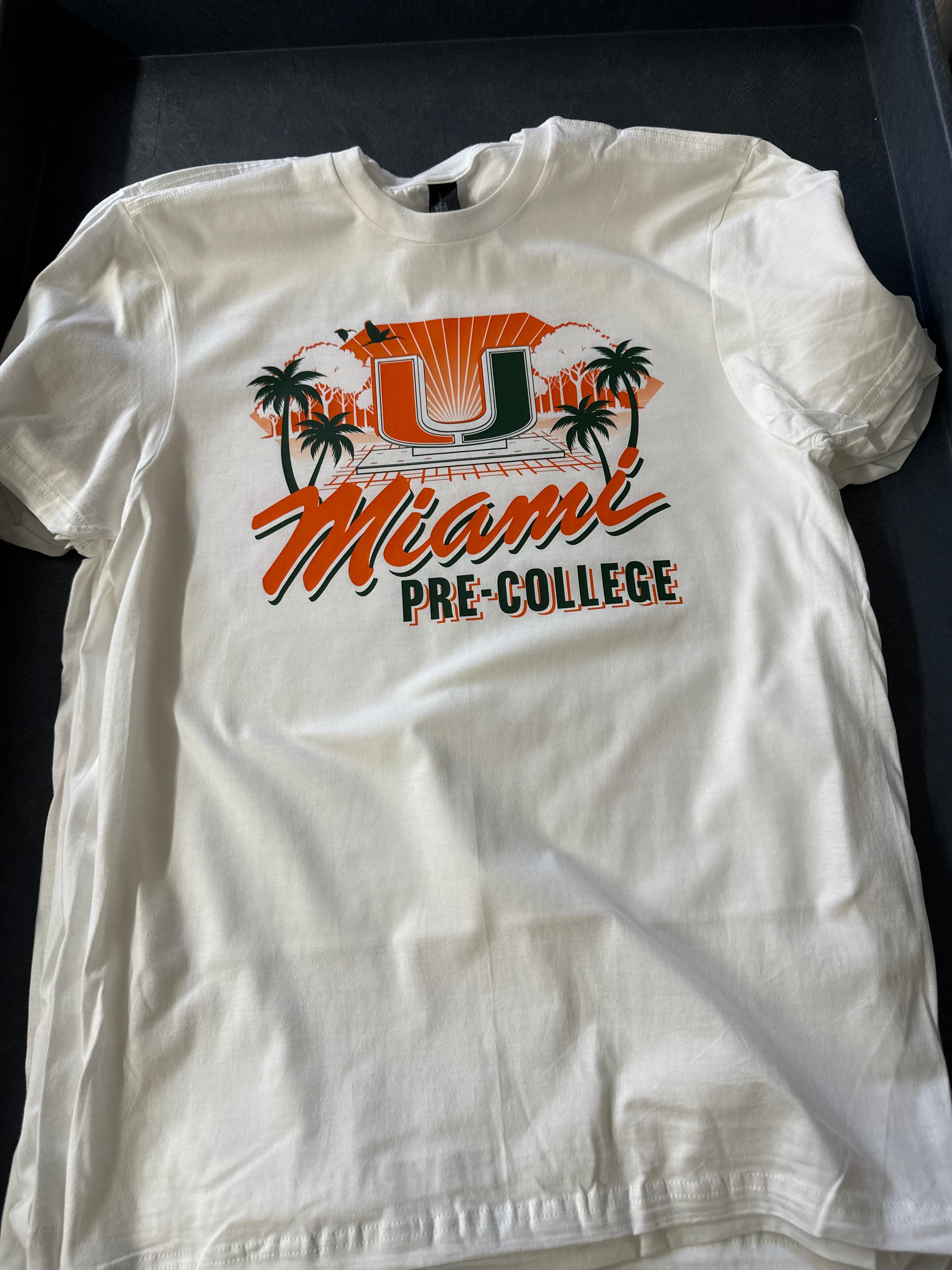 White t-shirt with a colorful graphic design on a dark surface