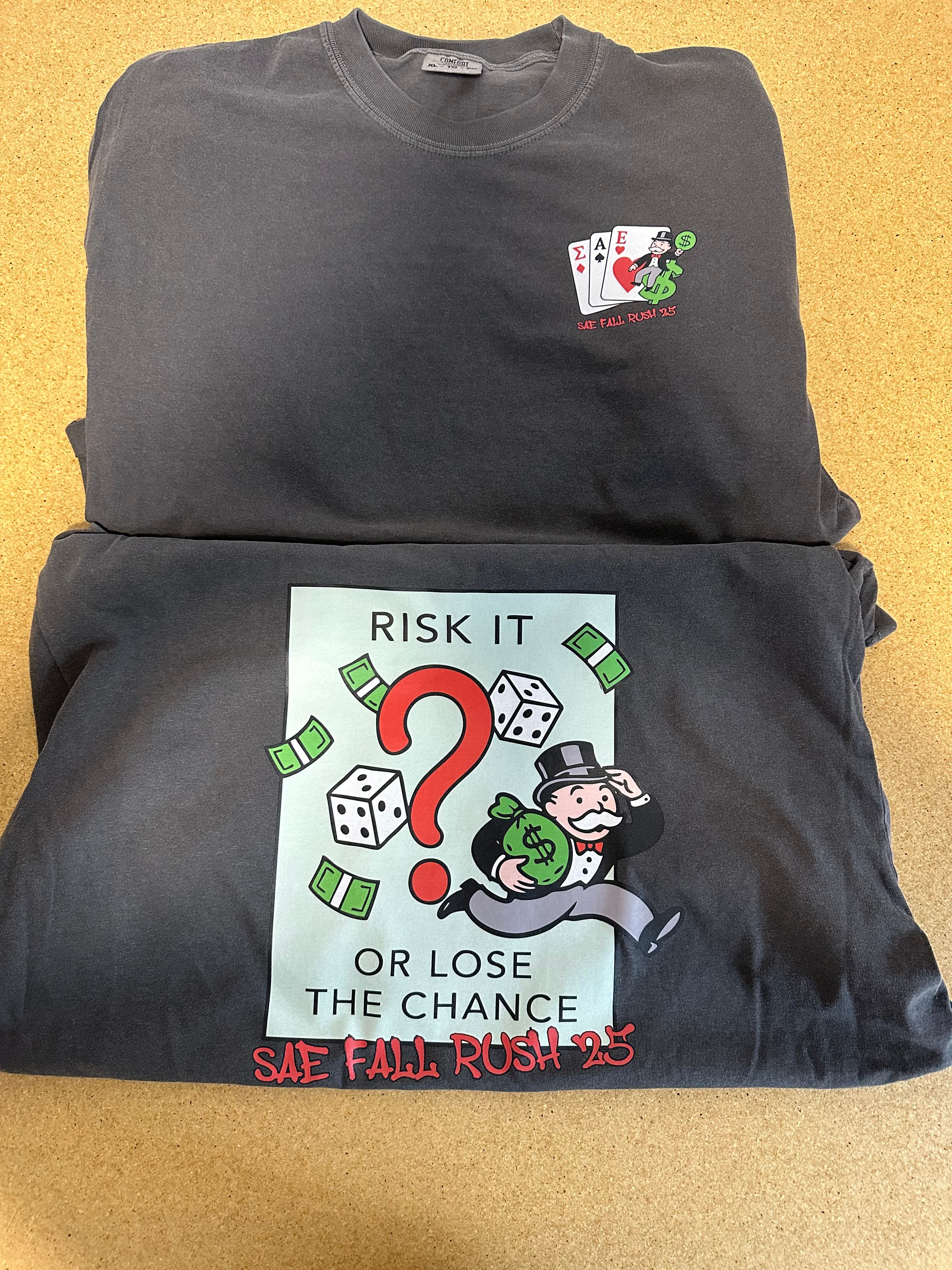 Two black t-shirts with graphic designs on a beige background
