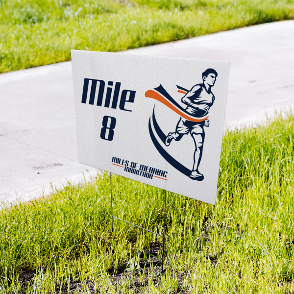 Marathon mile marker sign with a runner illustration on grass