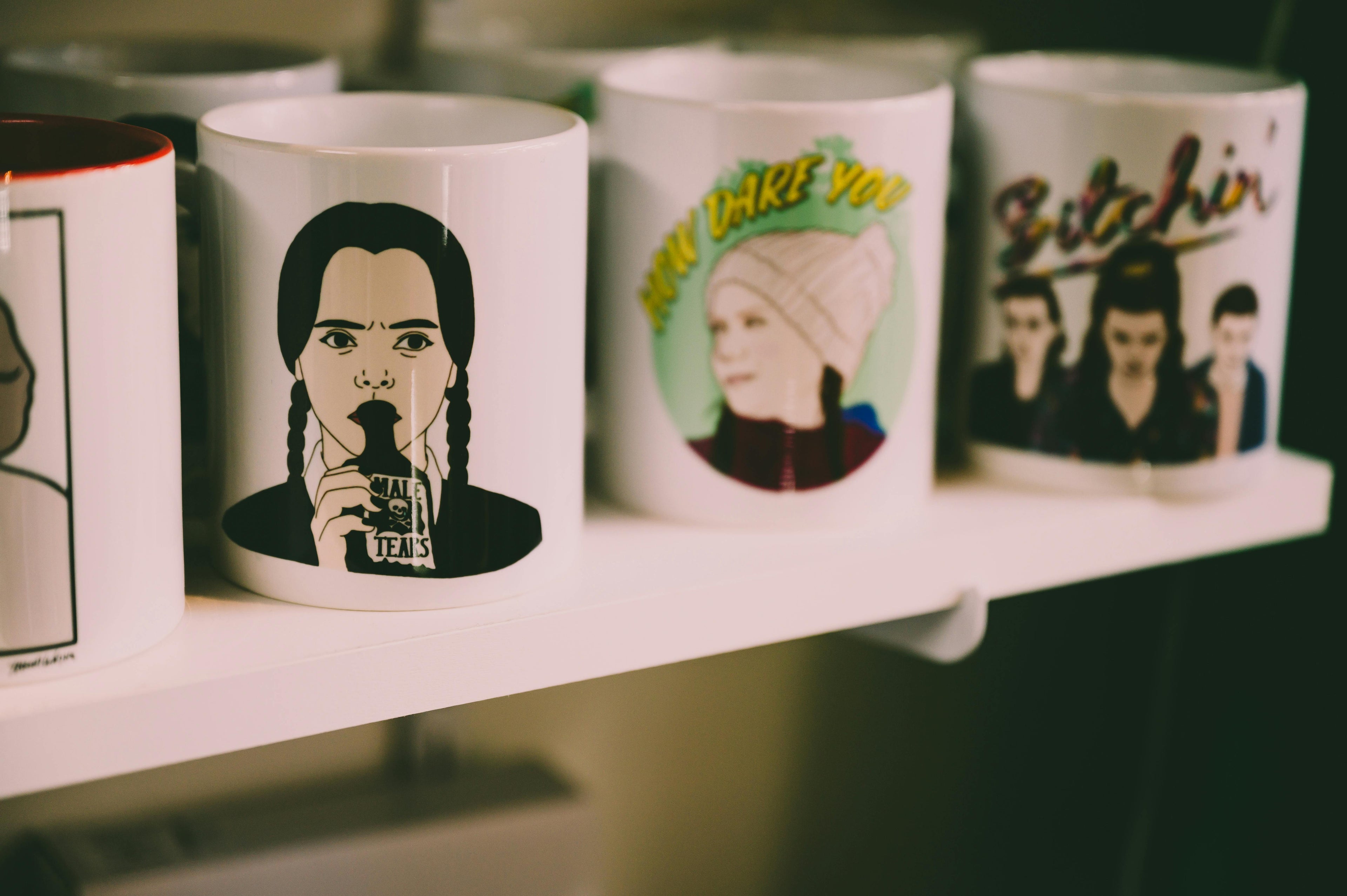 Custom printed mugs with graphic designs on a shelf