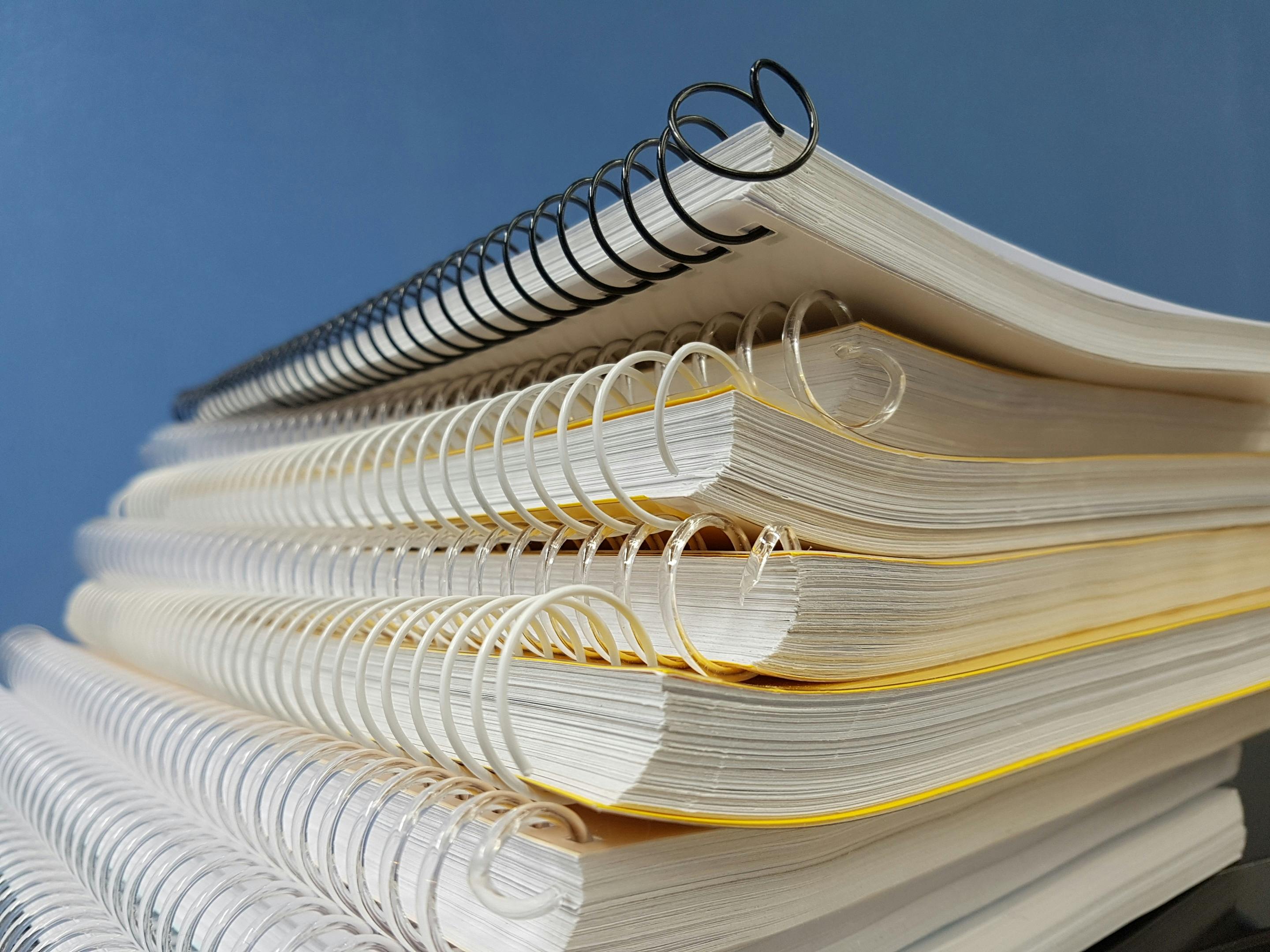Side view of a stack of custom notebooks with clean, branded covers.
