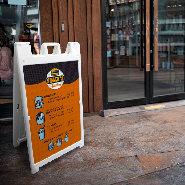 Outdoor menu sign for a restaurant with an orange background and white text, placed on a sidewalk.